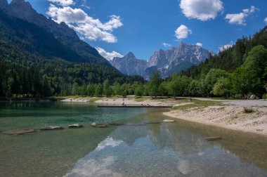 Jasna lake, Vrsic Pass, Kranjska gora, Slovenia - July 6, 2022: Touristic summer season with relaxing tourists in Julian Alps