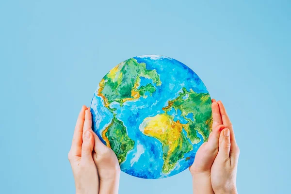 stock image Mother and son hold a picture of the Earth on a blue background. Save the planet. The concept of environmental protection and energy saving. High quality photo