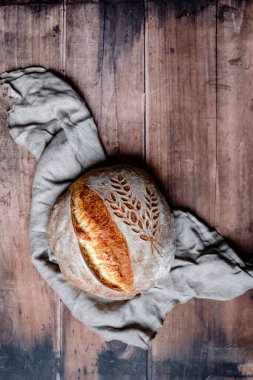 Rustic Italian Bread with Lievito Madre on a napkin on a wooden table. Organic and healthy bread on sourdough. top view. High quality photo