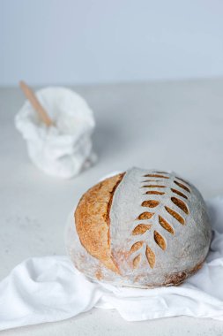Freshly baked Artisan sourdough bread loaves and bag of flour on white background. Low FODMAP Bread. Healthy food. . High quality photo