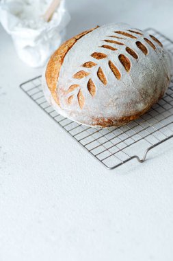Freshly baked Artisan sourdough bread loaves and bag of flour on white background. Low FODMAP Bread. Healthy food. Space for text. High quality photo