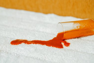 İçerideki beyaz halıda domates lekesi. Meyve suyunu yere dökmek. Yakın plan. Günlük yaşam lekesi konsepti. Yüksek kalite fotoğraf