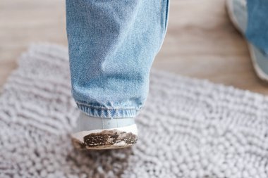 Gri halıda çamurlu ayak izleri. Çamurlu ve çamurlu kirli ayakkabılar. Günlük hayatın kirli lekeleri. Yüksek kalite fotoğraf