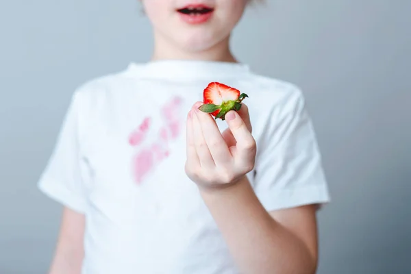 辣椒手拿着一片草莓和洒在白色T恤上的果汁 日常生活污迹的概念 高质量的照片 — 图库照片