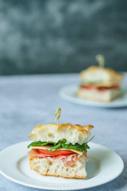 İtalyan yemeği: jambonlu, bebek sandviçli, domatesli ve roka soslu ev yapımı Toskana. İtalyan ekmeği. Yüksek kalite fotoğraf