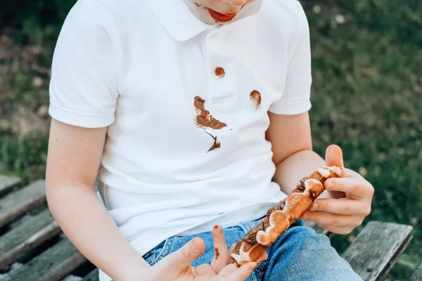 白色衣服上的巧克力污渍 一个用粘巧克力手吃比利时华夫饼的男孩 脏衣服 高质量的照片 — 图库照片