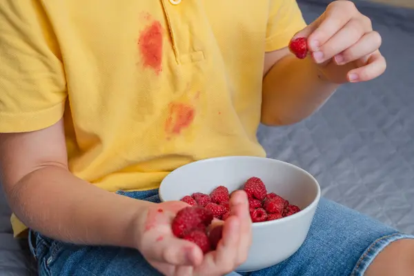 Dirt raspberry stains on yellow clothes. daily life stain concept. High quality photo
