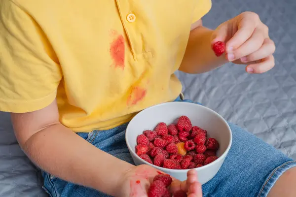 Dirt raspberry stains on yellow clothes. daily life stain concept. High quality photo