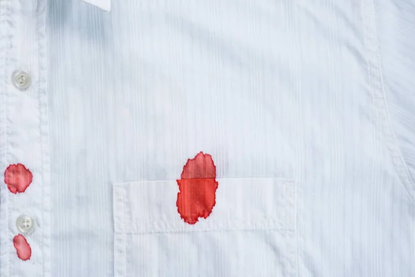 A drops of blood a white shirt. Stained clothing. daily life stain concept. Cleaning concept. top view. High quality photo
