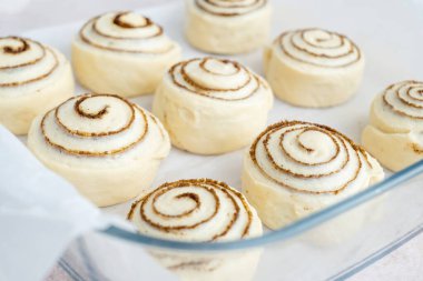 Çiğ, pişmemiş tarçınlı çörekler dinleniyor. Alternatif unlardan sağlıklı çörek pişirmek. Vejetaryen ekmeği. Kutlama yemeği. Yan görünüş. Yüksek kalite fotoğraf