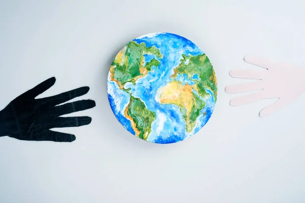 Multiracial hands black and light color reach globes. Save the planet.