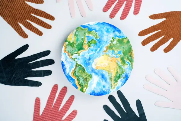 International Day for Tolerance with planet earth and the eight hands in a circle. Isolated on grey background. top view. High quality photo