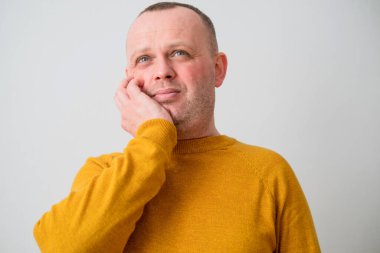 Sarı kazaklı bir adam diş ağrısı ya da diş hastalığından dolayı yanak ağrısına dokunuyor. Diş sağlığı sorunları konsepti. Yüksek kalite fotoğraf