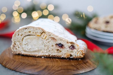 Noel 'i badem ezmesi, kurutulmuş meyve ve fındık dilimleyip arka plandaki Noel ışıklarının üzerine pudra şekeri serpiştirmek. Tatil pastası. Üst Manzara. Yüksek kalite fotoğraf