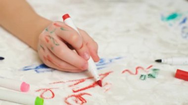 Kanepenin beyaz döşemelerine ya da halıya keçeli kalem çizen tanınmamış bir çocuk. Üst Manzara. Temizlik konsepti için kirli leke.