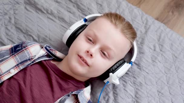 Młody Przystojny Chłopiec Białych Słuchawkach Leży Łóżku Domowym Wyluzuj Muzyką — Wideo stockowe