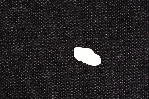 stock image Close up piece chewing gum on a fabric sofa living room. top view. dirty stains in daily life. High quality photo