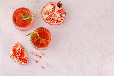 Refreshing pomegranate drinks garnished with fresh herbs on a light marble surface. top view. space for text. High quality photo clipart