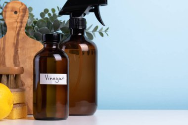 Kahverengi cam temizleme malzemeleri beyaz bir masada sünger, fırça ve taze limonla birlikte oturur ve organize ve davetkar bir temizlik düzeneği oluşturur. Yüksek kalite fotoğraf