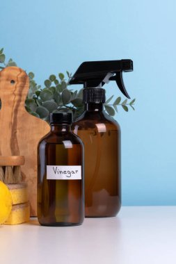 Kahverengi cam temizleme malzemeleri beyaz bir masada sünger, fırça ve taze limonla birlikte oturur ve organize ve davetkar bir temizlik düzeneği oluşturur. Metin için boşluk. Yüksek kalite fotoğraf