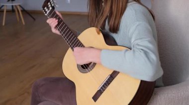 Konforlu bir oturma odasında gitar çalan, çeşitli tıngırtı şekilleri sergileyen, daha düşük görüş açılı bir kişi. Sıcak atmosfer, müziğin tadını çıkarırken rahatlamaya davet eder..