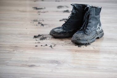 Ahşap zeminde çamurlu çizmeler. 