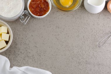 Pişirme malzemeleri tereyağı, un, yumurta, süt, reçel ve bir kasede pişmiş üçgen kurabiye. Geleneksel Yahudi Hamantaschen kurabiyeleri. Purim tatili. Üst Manzara. Yüksek kalite fotoğraf