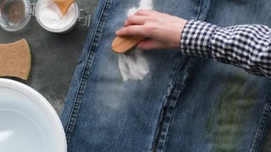 Alternatif teknikler kot pantolonlardaki inatçı çimen lekelerini çıkarmak için temel ev ürünlerini kullanırlar. Dişi bir el fırçayla kabartma tozu sürer. Yüksek kalite 4k görüntü