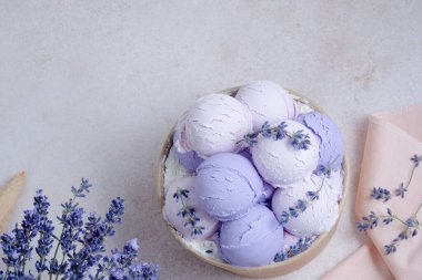 Gri arka planda lavantalı lavantalı dondurmayı kapayın ve lavanta çiçekleriyle süsleyin. Sağlıklı dondurulmuş tatlı. Tatlı vejetaryen kahvaltısı. Yüksek kalite fotoğraf