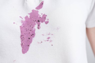 Beyaz gömleklerine mor dondurma döküldü. Rahatlamış atmosfer bir anlık eğlenceyi işaret ediyor. Kıyafetlerdeki günlük lekeler. Yüksek kalite fotoğraf