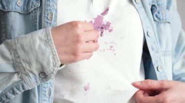 Beyaz gömleğe mor dondurma döküldü. Tanınmayan birinin eli bir peçeteyle lekeyi siler. Giysilerdeki günlük lekeler