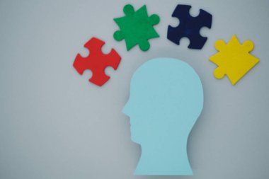 Gri arka planda renkli yapboz parçaları olan mavi bir kafa silueti. Akıl sağlığı kavramı ve kapsayıcı bir toplum oluşumu. Üst Manzara. Yüksek kalite fotoğraf