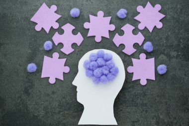 Sembol olarak mor ponponu olan insan beyni. Beton zeminde bulmaca parçaları olan Alzheimer hastaları. Zihinsel sağlık sorunları ve hafıza sorunları. Yüksek kalite fotoğraf