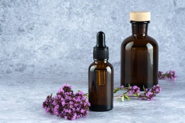 Organik yağlar, bitkisel özler kehribar şişesi, içinde kekik çiçekleri olan bir damla. Alternatif terapi, aromaterapi. Nemlendirici cilt bakımı, aromaterapi. 