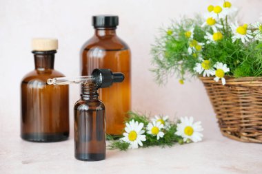 Bitkisel ilaçlar için doğal estetik ideal. Kahverengi cam şişeler bir papatya çiçeğinin yanında ustalıkla dizilmiş. Alternatif tıp, sağlıklı ve sağlıklı konsept. Yüksek kalite fotoğraf