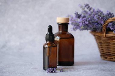 Taze lavanta filizlerinin yanında sergilenen lavanta özü yağı dolu iki kehribar rengi cam şişe. Alternatif tıp, sağlıklı ve sağlıklı konsept. Yüksek kalite fotoğraf