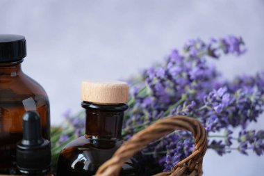 Doğal güzellik ürünlerini kapatın kehribar cam şişeleri lavanta esaslı yağlarla dolu sepette taze lavanta filizleriyle. Alternatif tıp, organik kozmetik, kendine bakım ve refah konsepti. - Evet. Yüksek kalite fotoğraf