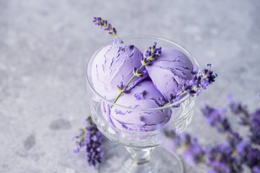 Kremalı lavantalı dondurma cam tabakta sunuluyor. Sağlıklı dondurulmuş tatlı. Tatlı vejetaryen kahvaltısı. Yüksek kalite fotoğraf