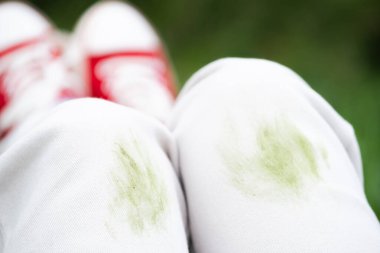 Yaz etkinliği sırasında beyaz kotlardaki kirli çimen lekelerini kapatın. Giysi bakımı ya da leke çıkarma. Kıyafetlerdeki günlük lekeler. - Evet. Yüksek kalite fotoğraf