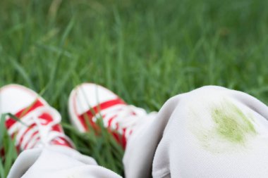 Yaz etkinliği sırasında beyaz kotlardaki kirli çimen lekelerini kapatın. Giysi bakımı ya da leke çıkarma. Kıyafetlerdeki günlük lekeler. - Evet. Yüksek kalite fotoğraf