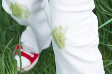 Yaz etkinliği sırasında beyaz kotlardaki kirli çimen lekelerini kapatın. Giysi bakımı ya da leke çıkarma. Kıyafetlerdeki günlük lekeler. - Evet. Yüksek kalite fotoğraf