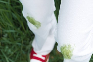 Yaz etkinliği sırasında beyaz kotlardaki kirli çimen lekelerini kapatın. Giysi bakımı ya da leke çıkarma. Kıyafetlerdeki günlük lekeler. - Evet. Yüksek kalite fotoğraf