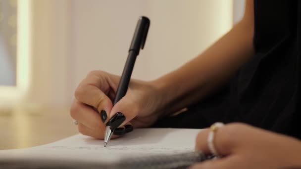 Hand Van Jonge Vrouw Met Zwarte Nagels Schrijft Notitieboekje Doet — Stockvideo
