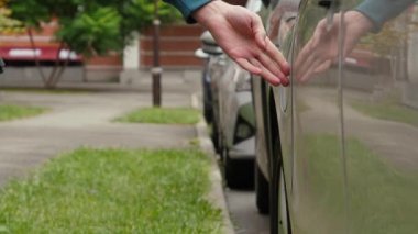 Erkek el şarj cihazının kapağını açar ve güç bağlantısını EV vagonuna yerleştirir. Tanınmayan adam elektrik kablosunu elektrikli arabaya bağlıyor ve pilleri şarj ediyor.