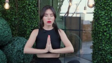 Güzel bir kadın, meditasyon yapıyor gözleri kapalı, iç uyumu ve dengeyi hissediyor. Kadın video konferansına katılıyor, müşterilerle uzaktan pazarlık yapıyor. Çalışma ve öğrenim için video eğitimi