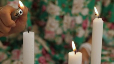 Sihirli ayine hazırlanan kadın eli. Renkli elbiseli tanınmayan kadın mum yakıyor..