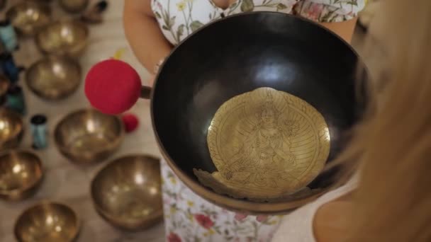 佛教音乐疗法仪式 难以辨认的女人用柔软的木槌敲着藏人的碗 — 图库视频影像