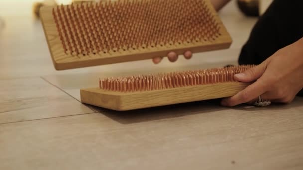 女人准备了一个沙胡牌 因为它是用钉子钉在木板上的 女士要站在瑜伽钉板上 — 图库视频影像