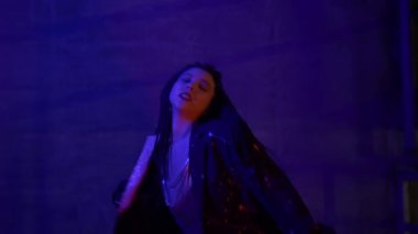 Güzel seksi Asyalı kadın yavaşça dans ediyor, örgülü saçlarını sallıyor, ağır çekimde