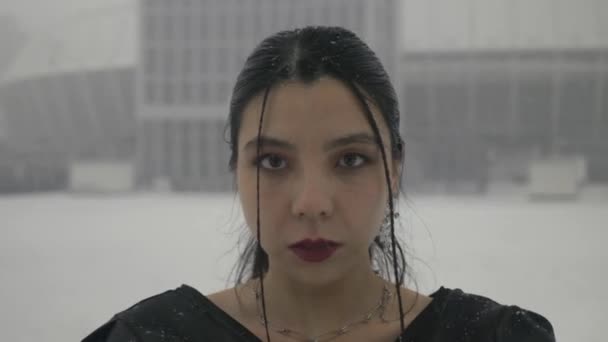 一个亚洲女人的画像 在雪地里看着相机 享受着自由的活力 穿着黑色浅色夏装的女士在雪城的背景下 — 图库视频影像